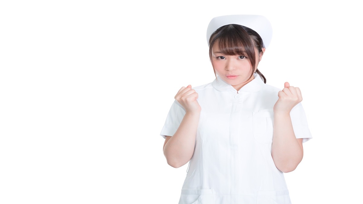 困った表情で拳を作っている女性看護師